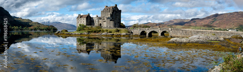 A panorama of the Eilean Donan Castle on a sunny afternoon in Scotland.