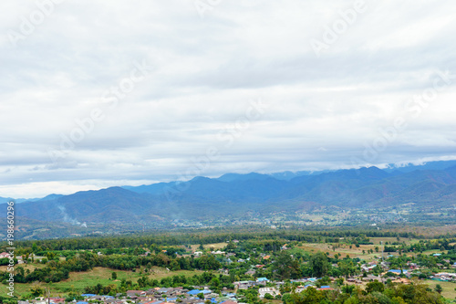 panorama landscape of field and local village with sky and cloud and layer of mountain background