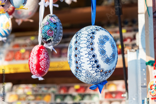 Wide selection of easter eggs, traditional souvenirs in the kiosk of street market during celebration of Easter in Central  Europe. Compartments full of colourfull eggs. Focis on white egg. photo