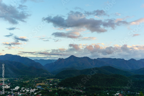 Amazing local city and wild nature view of layer of mountain forest landscape with cloudy sky at winter season. Natural green scenery of cloud and mountain slopes background. Maehongson,Thailand