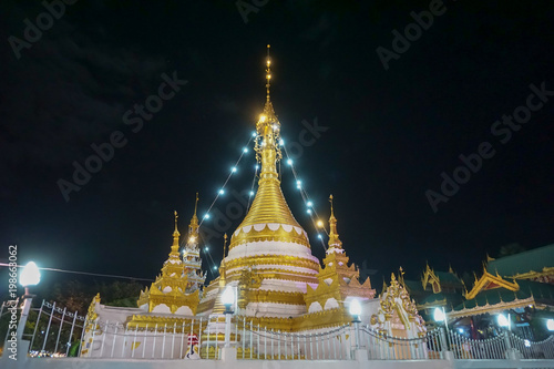 panorama landscape view of temple and pagoda decorated with light at night near the big pond.Mae Hong Son,Thailand.