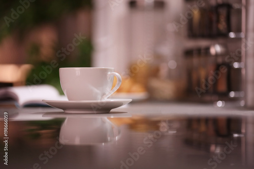 Cup of hot coffee on blurred background