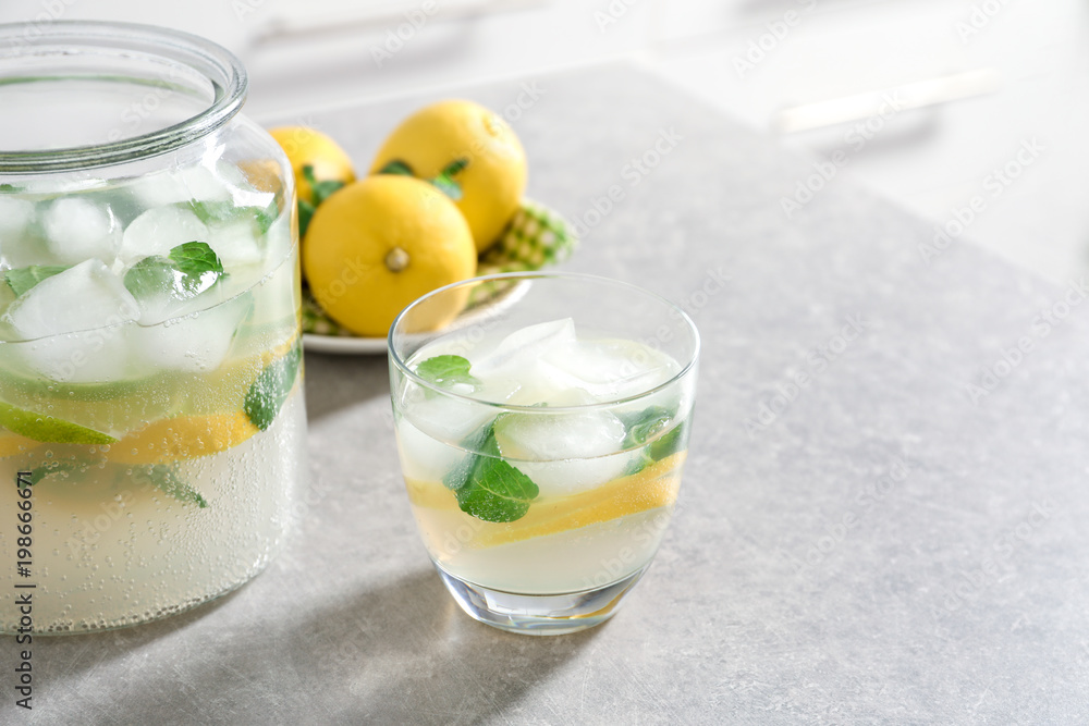 Fototapeta premium Jar and glass of fresh lemonade on table
