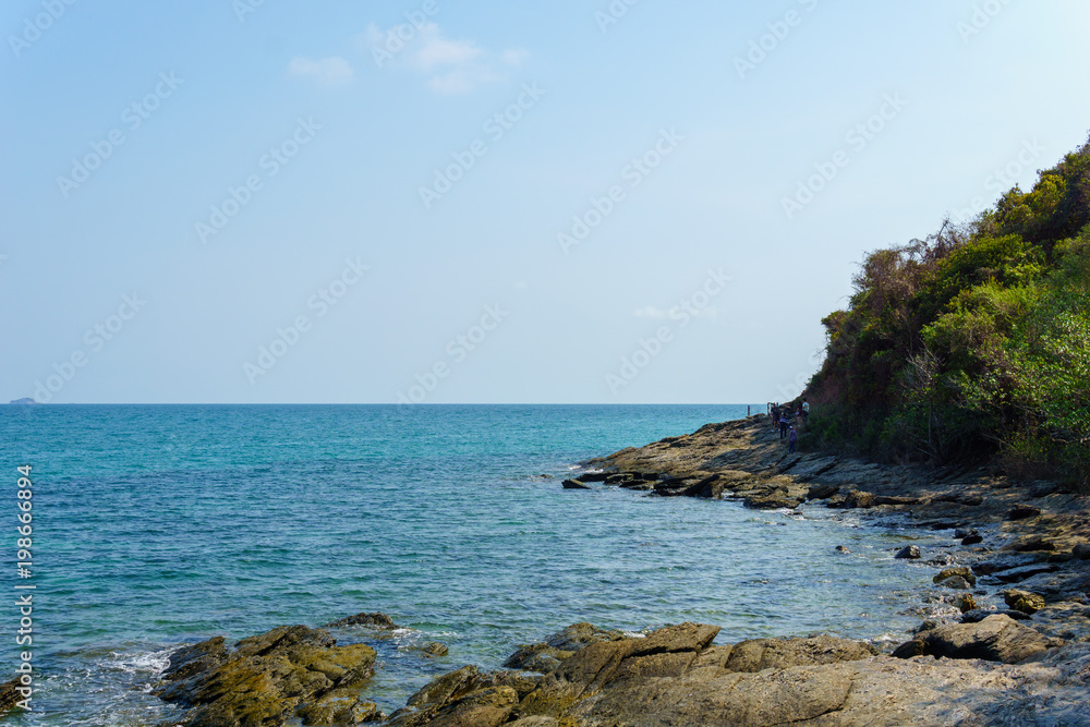 landscape panorama view of The large rocks and the beach in the clear blue sea and the waves hit it with blue sky in sunny day.