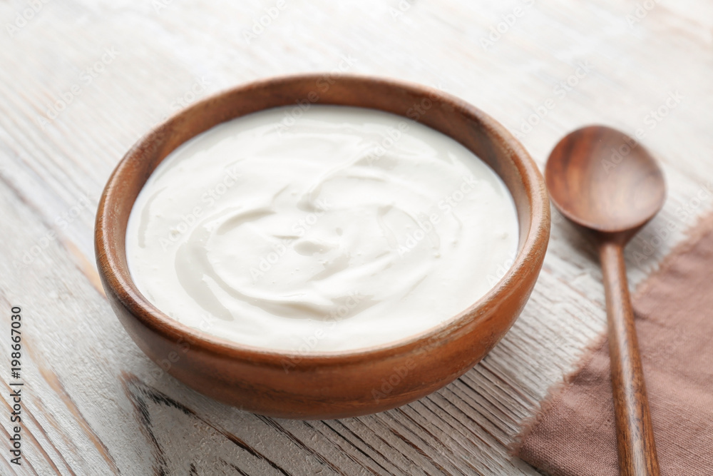 Bowl with tasty yogurt on wooden table Bowl with tasty yogurt on wooden table