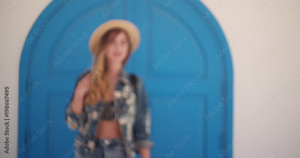 Woman on Mediterranean vacations standing in front of blue door Woman on Mediterranean vacations standing in front of blue door