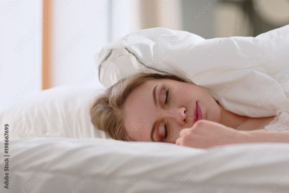 Pretty woman lying down on her bed at home Pretty woman lying down on her bed at home