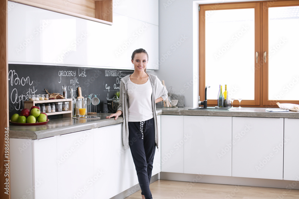 Happy woman drinking tea in the kitchen at home Happy woman drinking tea in the kitchen at home