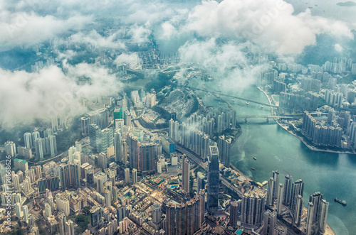 Bird's eye or aerial view through the clouds to large metropolis city of Hong Kong.