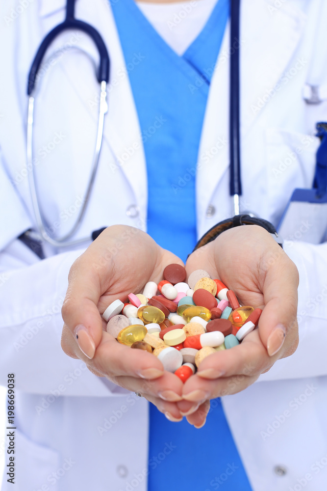 Doctor holding heap of drugs in a hand Doctor holding heap of drugs in a hand