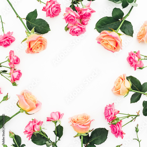Round floral frame of roses, buds and green leaves on white background. Flat lay, top view. Spring background
