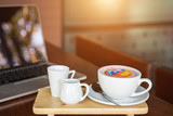 White coffee cup on wooden table or counter in coffee shop and blur light bokeh background