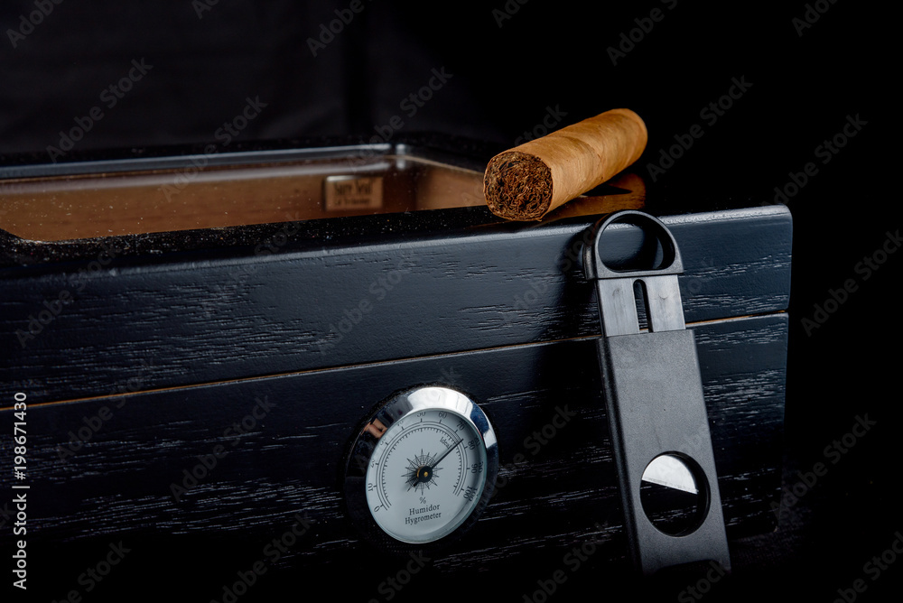 Cigars on a humidor against a black background