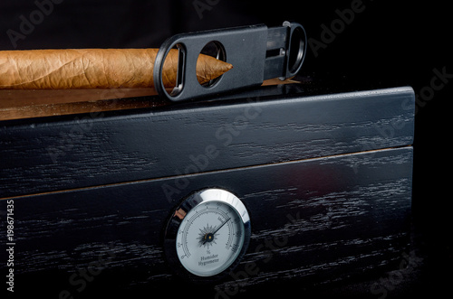 Fotografia Cigars on a humidor against a black background