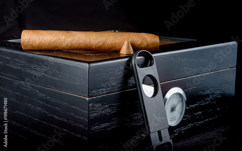 Cigars on a humidor against a black background photo