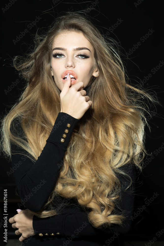 Foto Stock Passionate sexy woman with long hair, perfect makeup, long thick  eyelashes, open mouth, white teeth, touches finger lips. Sensual blonde  model in black clothes. Cosmetic, skincare, haircare concept. | Adobe