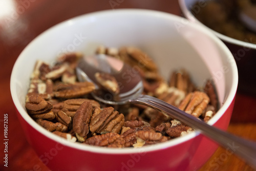 Healthy eating snack concept. Pecan kernel nuts in red with spoon