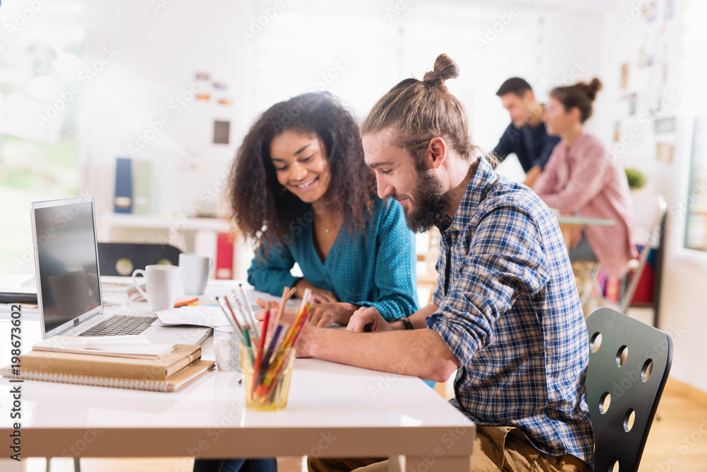 At college. A group of multi-ethnic students working on a common At college. A group of multi-ethnic students working on a common