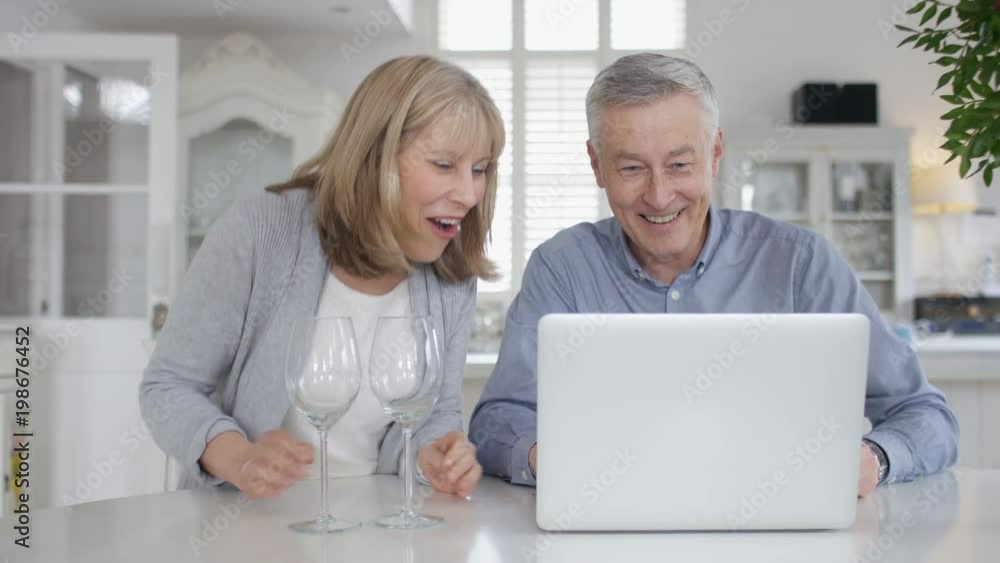 Mature older couple on a video call on their laptop Mature older couple on a video call on their laptop