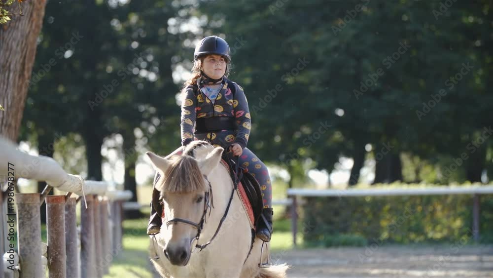 Child riding Fjord horse in outdoor arena in slow motion 4K Child riding Fjord horse in outdoor arena in slow motion 4K