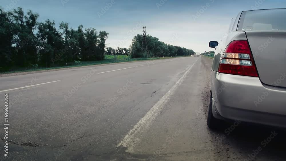 Car is on the sidelines, flashing emergency lights, cars passing by, opacity 50 procents Car is on the sidelines, flashing emergency lights, cars passing by, opacity 50 procents
