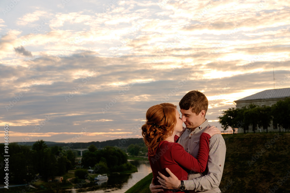 Happy smiling lovely couple at honey summer sunset Happy smiling lovely couple at honey summer sunset