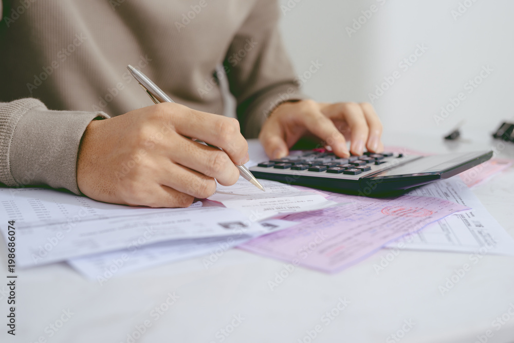 Hand man doing finances and calculate on desk about cost at home office. Hand man doing finances and calculate on desk about cost at home office.