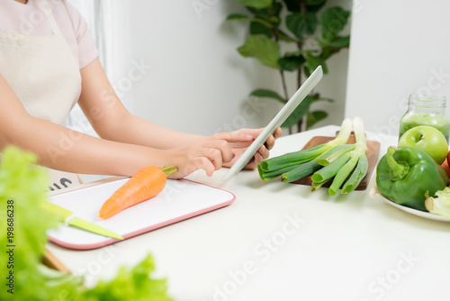 Woman using tablet to prepare food