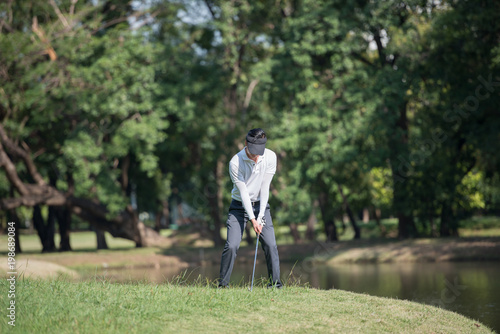 Golfers asia man show hit sweeping at green lawn.