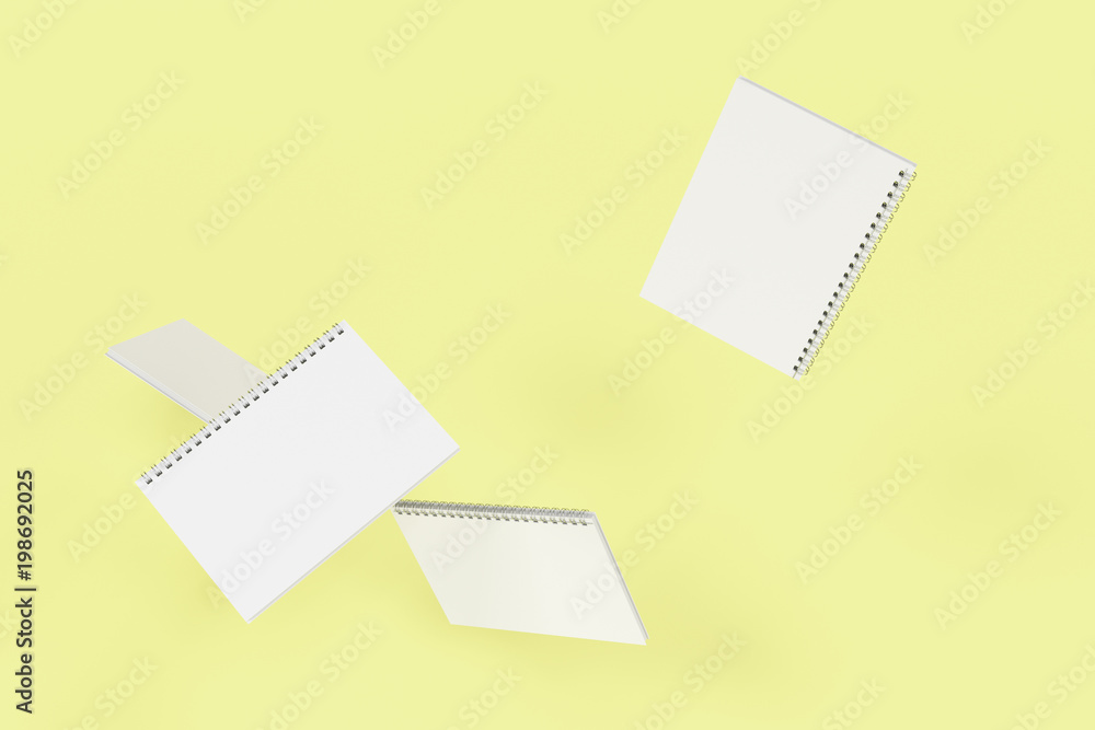 Four notebooks with spiral bound on yellow background Four notebooks with spiral bound on yellow background