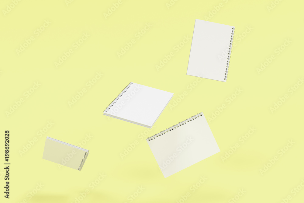 Four notebooks with spiral bound on yellow background Four notebooks with spiral bound on yellow background