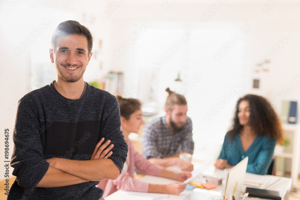 At the office. Portrait of a young man looking at the camera At the office. Portrait of a young man looking at the camera