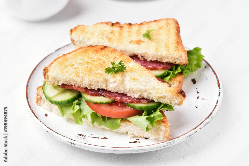 Club sandwiches with salami, tomatoes, cucumber and lettuce