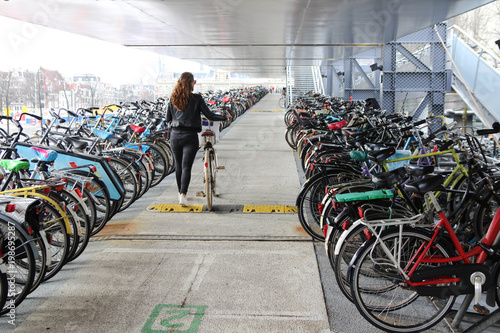 Wallpaper Mural A young woman in the parking of a bicycle Torontodigital.ca
