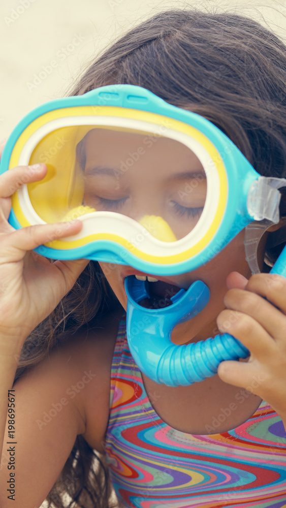 Portrait of the happy children with swimming mask on head playing onthe sea beach.