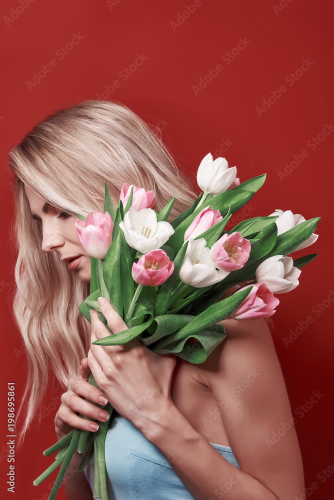 young girl in a blue dress with white and pink tulips on a red background