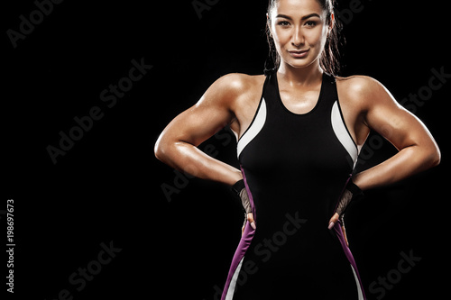 A strong athletic, woman on black background wearing in the sportswear, fitness and sport motivation. © Mike Orlov