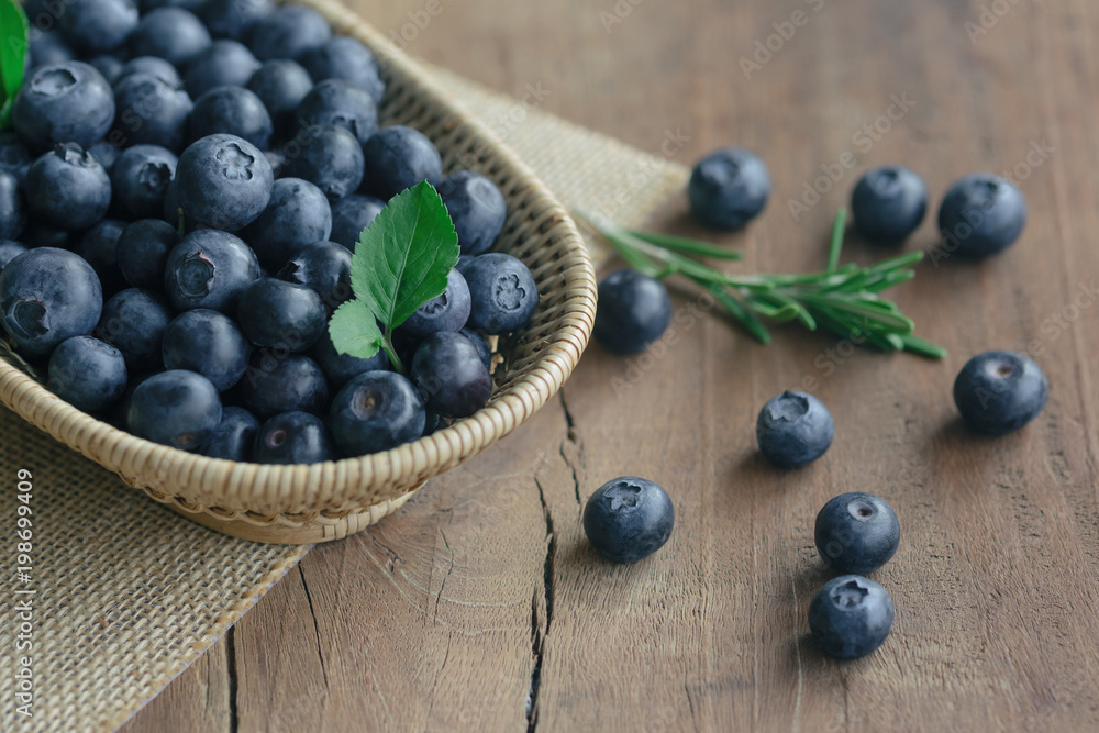 Fresh wild blueberries in wood basket on sack put on wooden table with copy space for background, selective focus. Blueberry is healthy and delicious fruits which have high antioxidant and vitamin C. Fresh wild blueberries in wood basket on sack put on wooden table with copy space for background, selective focus. Blueberry is healthy and delicious fruits which have high antioxidant and vitamin C.