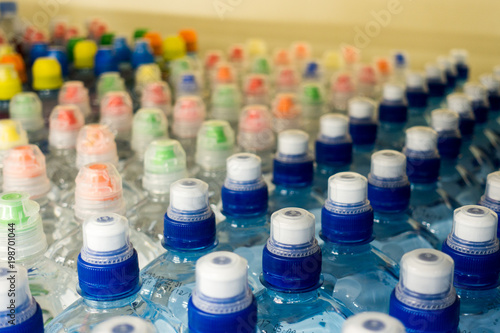 Drinking water, multi-colored plastic cap. Bottle caps on the market close up.