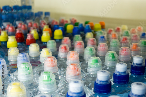 Drinking water  multi-colored plastic cap. Bottle caps on the market close up.