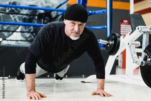 Adult man doing push-ups in the gym