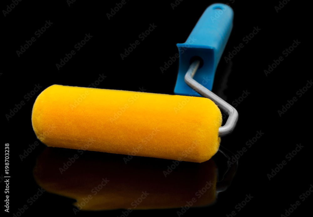 Obraz premium Paint roller on black reflective background.
