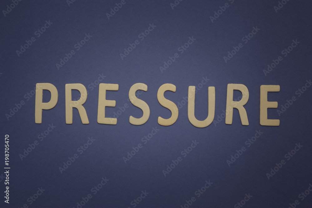 Pressure written with wooden letters on a blue background Pressure written with wooden letters on a blue background