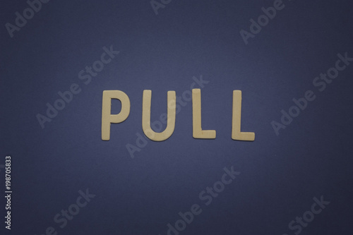 Pull written with wooden letters on a blue background