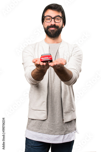 Hipster man holding little car on white background