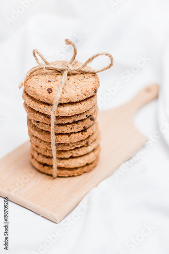 Photo of a homemade cookies wrapped with rope on a wooden board