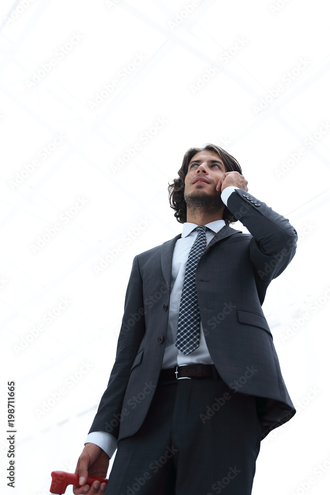 bottom view.businessman with Luggage talking on a cell bottom view.businessman with Luggage talking on a cell