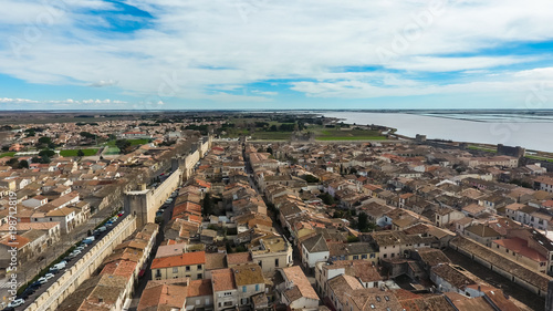 Medieval stone fortified fortress town Aigues-Mortes in France. Aerial view of tiled roofs and stone city wall