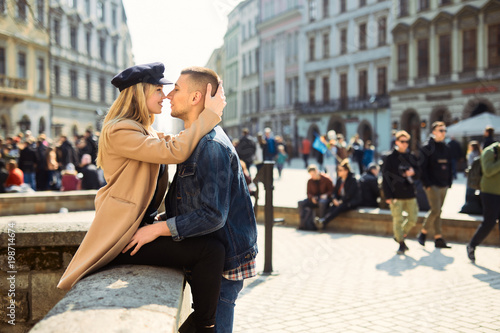 Lovely couple stand on city landscape and hug each other with sun on background © Serhiy Hipskyy