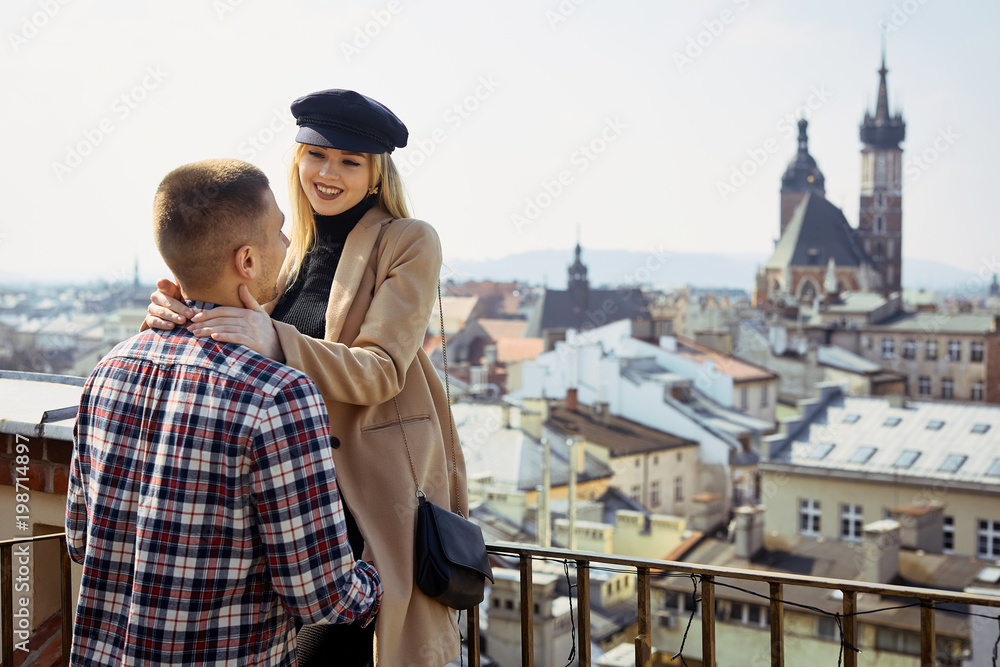 Lovely couple stand on city landscape and hug each other